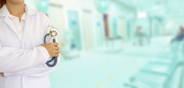 Elinde üniformalı bir steteskop olan bir tıp doktoru. Hastanenin geçmişi bulanık. Sabahın altın ışığı camdan süzüldü, sıcacık görünüyordu..