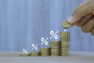 Artan faiz oranları, finansal büyüme veya yatırım geri dönüşlerini gösteren yüzdelik sembollerle yükselen bir yığına para koymak. Finansal ve iş kavramları için ideal.