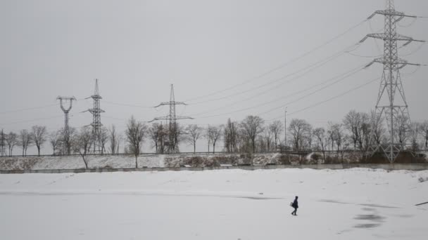 Pescador caminando sobre un lago congelado cubierto de hielo — Vídeos de Stock