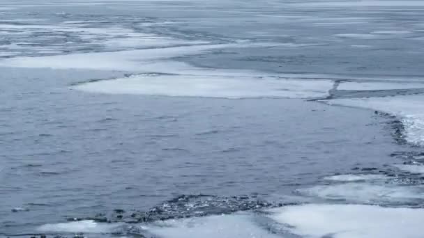 Timelapse of water waves on partially frozen lake with blocks of ice — стоковое видео