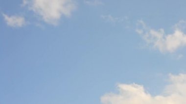 Cumulus and cirrus clouds move quickly on background of blue sky