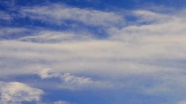 Kümülüs ve cirrus bulutları mavi gökyüzünün arka planında hareket