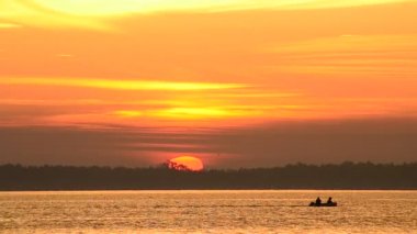 Motorlu tekne su ile güneş ufukta güneş doğarken taşır