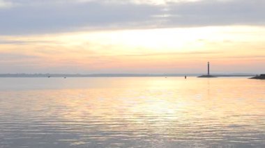 Su, yatay, deniz feneri ve gökyüzü daybreak sırasında