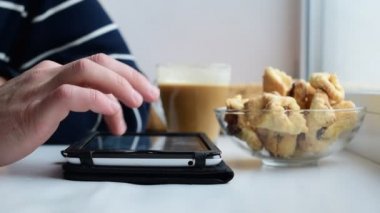 Ellerini beyaz adamın tablet pencere pervazına üzerinde kullanma