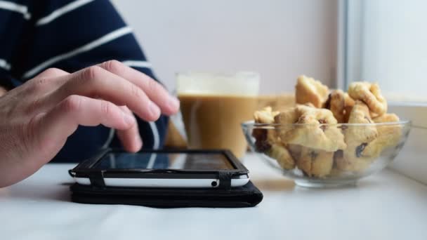 Manos de hombre caucásico usando tableta en alféizar de ventana — Vídeos de Stock