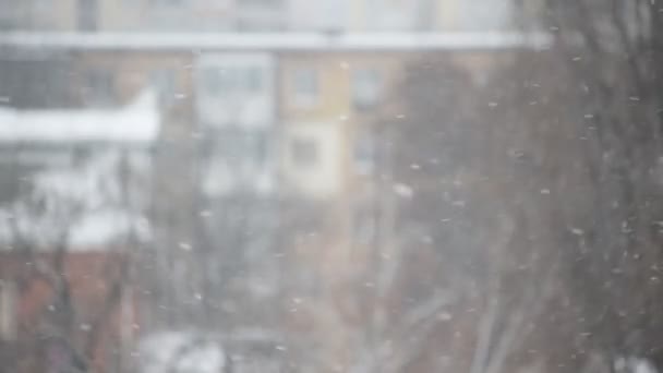 Neige tombant dans la ville sur fond flou 