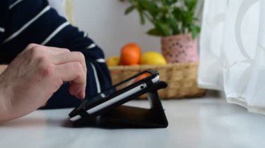 Genç erkek tablet pencere pervazına üzerinde kullanır.