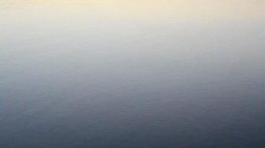 Taş daireler üreten sakin mavi suya düşüyor