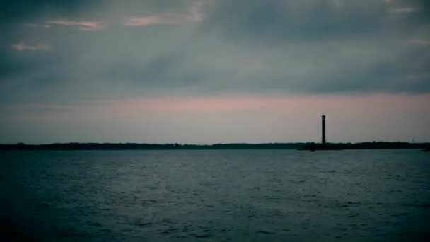 Zeitraffer bei Tagesanbruch über dem Wasser mit Leuchtturm — Stockvideo