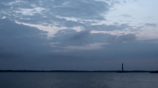 Zeitraffer des Tagesanbruchs über Wasser mit Leuchtturm und Wolken — Stockvideo