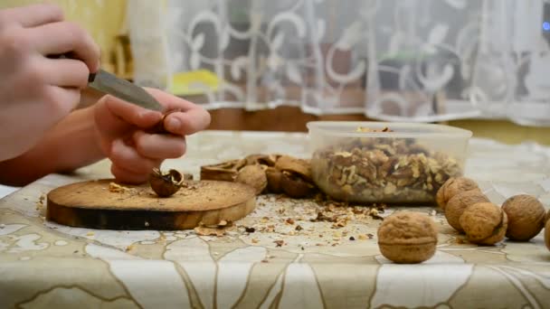 Adolescente agrietando nueces con un cuchillo — Vídeos de Stock