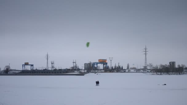 Family using a kite on frozen water storage reservoir — Stock Video