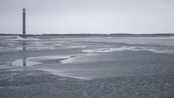 Faro de día sobre depósito de agua parcialmente congelado — Vídeos de Stock