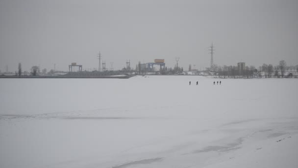 Група людей, що ходять по замерзлому водосховищу — стокове відео