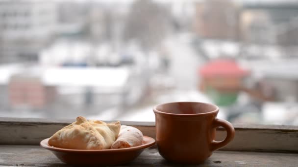 Tasse mit Heißgetränk dampft und Brötchen auf Untertasse — Stockvideo