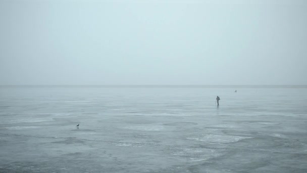 Winter fisherman making hole in ice with an ice chisel — ストック動画