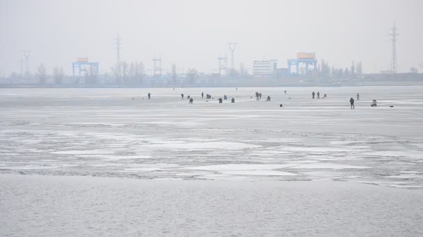 Pescadores pescando sobre hielo en el fondo de la central eléctrica — Vídeo de stock