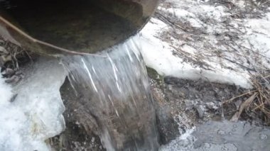 Kışın demir borudan dereye su akar.