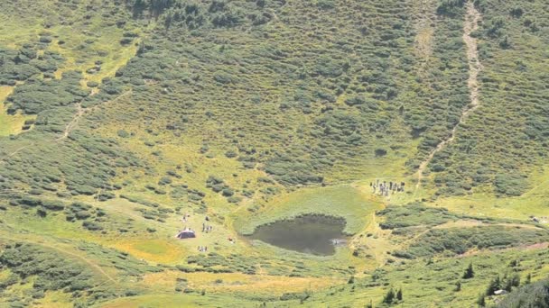 Τοπίο με τους ανθρώπους κοντά σε μια λίμνη στα βουνά — Αρχείο Βίντεο