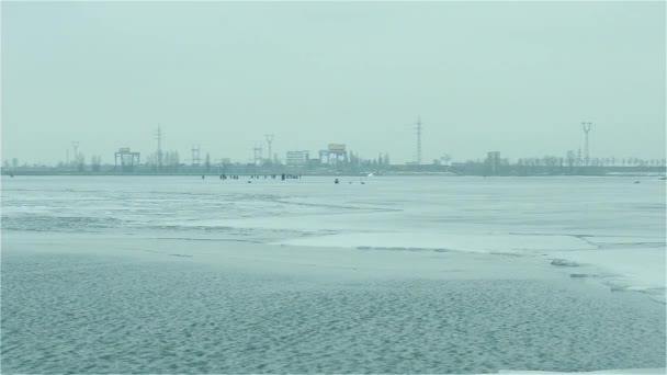 Winter anglers on ice on background of hydroelectric power plant — Stock video