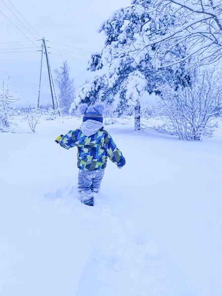 Derin karda koşan çocuk.