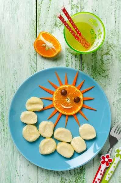 Barn frukost lata dumplings och orange i form av den — Stockfoto