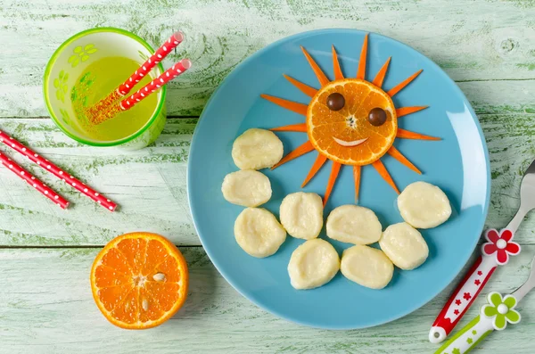 Children breakfast lazy dumplings and orange in the shape of the