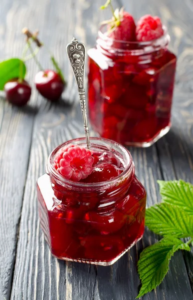 Confiture de cerises et framboises sur une table rustique en bois — Photo