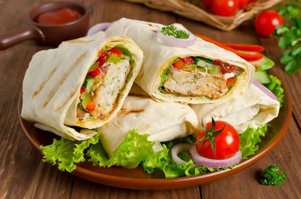 Tortilla fresca envuelve con kebab y verduras frescas en el plato — Foto de Stock