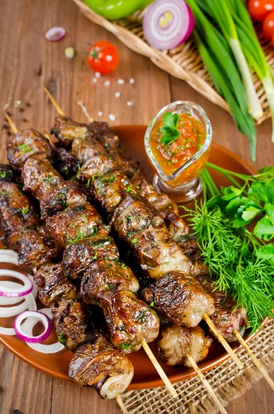 Grilled beef liver kebabs on a dark wooden background