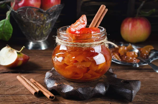 Homemade sweet apple jam with cinnamon. Jam in a jar on a wooden table.