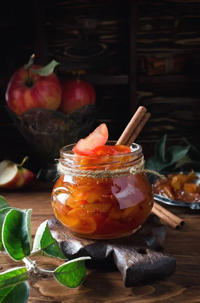 Homemade sweet apple jam with cinnamon. Jam in a jar on a wooden table.