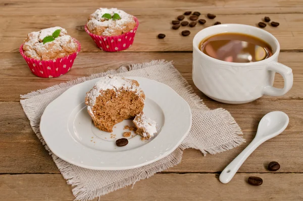 Muffins med kaffe på trä bakgrund — Stockfoto