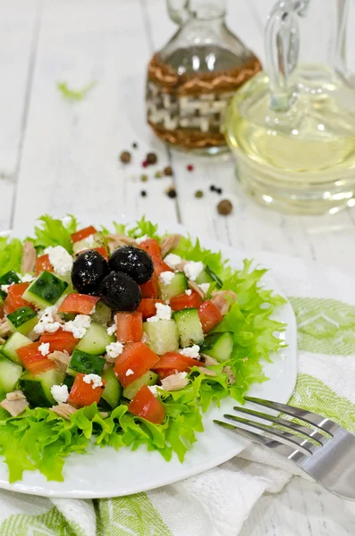 Свежий салат с тунцом, помидорами и огурцами на белом столе — стоковое фото