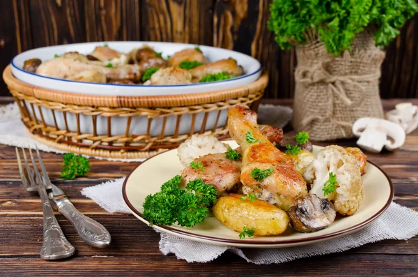 Pieczone udka z ziemniakami, champignon i kalafior — Zdjęcie stockowe