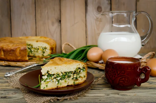Pie with onions and eggs on the wooden table — Stock Photo, Image