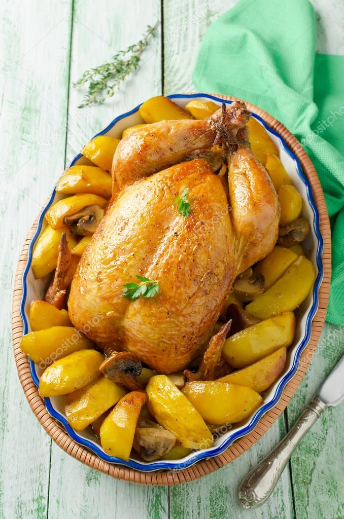 Whole roasted chicken with potatoes and mushrooms