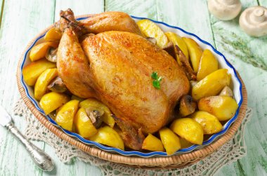 Whole roasted chicken with potatoes and mushrooms clipart
