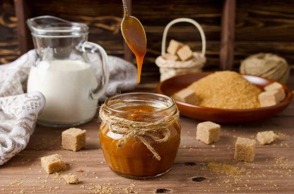 Salsa al caramello fatta in casa sul tavolo di legno — Foto Stock