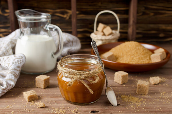 Homemade caramel sauce on wooden table