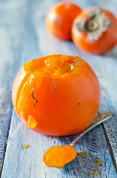 Ripe sweet persimmons on wooden table — Stock Photo, Image