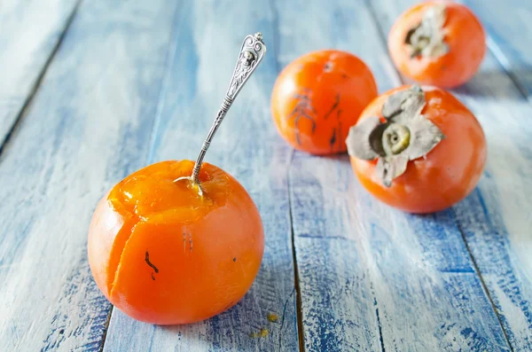 Ripe sweet persimmons on wooden table — Stock Photo, Image