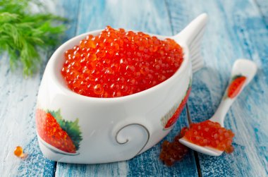 Mavi ahşap arka plan üzerinde kırmızı somon havyar