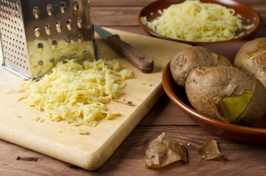 Patates ve bir kesme tahtası üzerinde patates rendesi