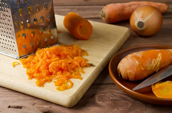 Carrot and grated carrot on a cutting board — Stock Photo, Image