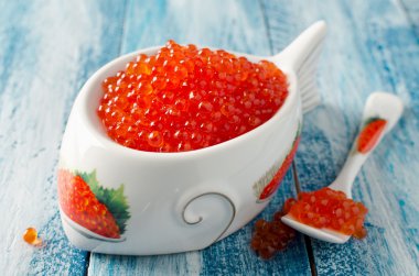 Mavi ahşap arka plan üzerinde kırmızı somon havyar