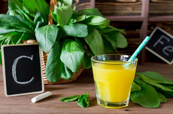 Fresh spinach in a basket and orange juice on the table. Source — Stock Photo, Image