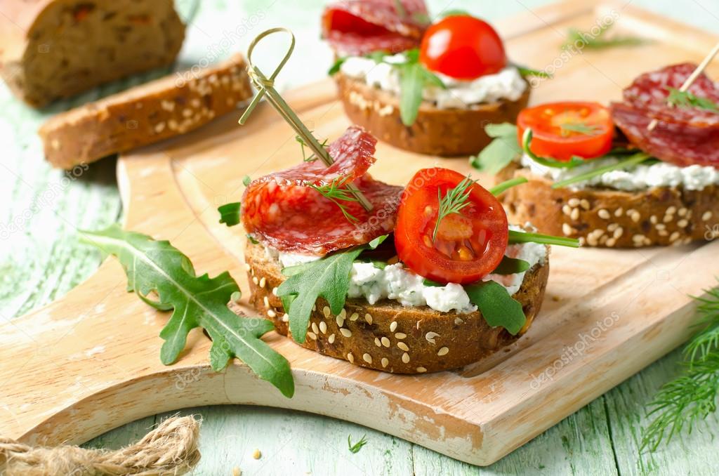 Sandwiches with salami, cherry tomatoes and arugula