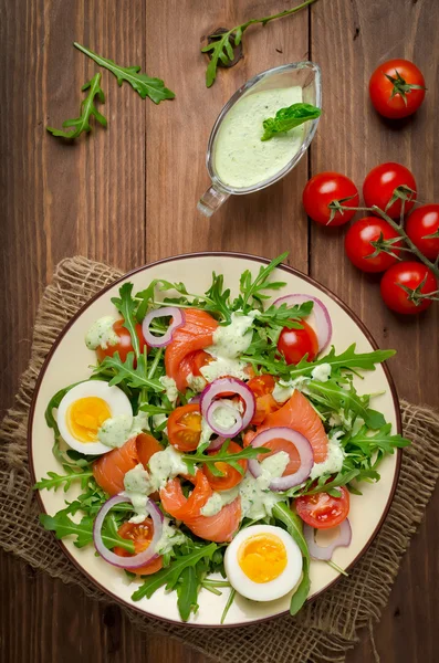 Rökt lax sallad med rucola, tomater, ägg och rödlök — Stockfoto